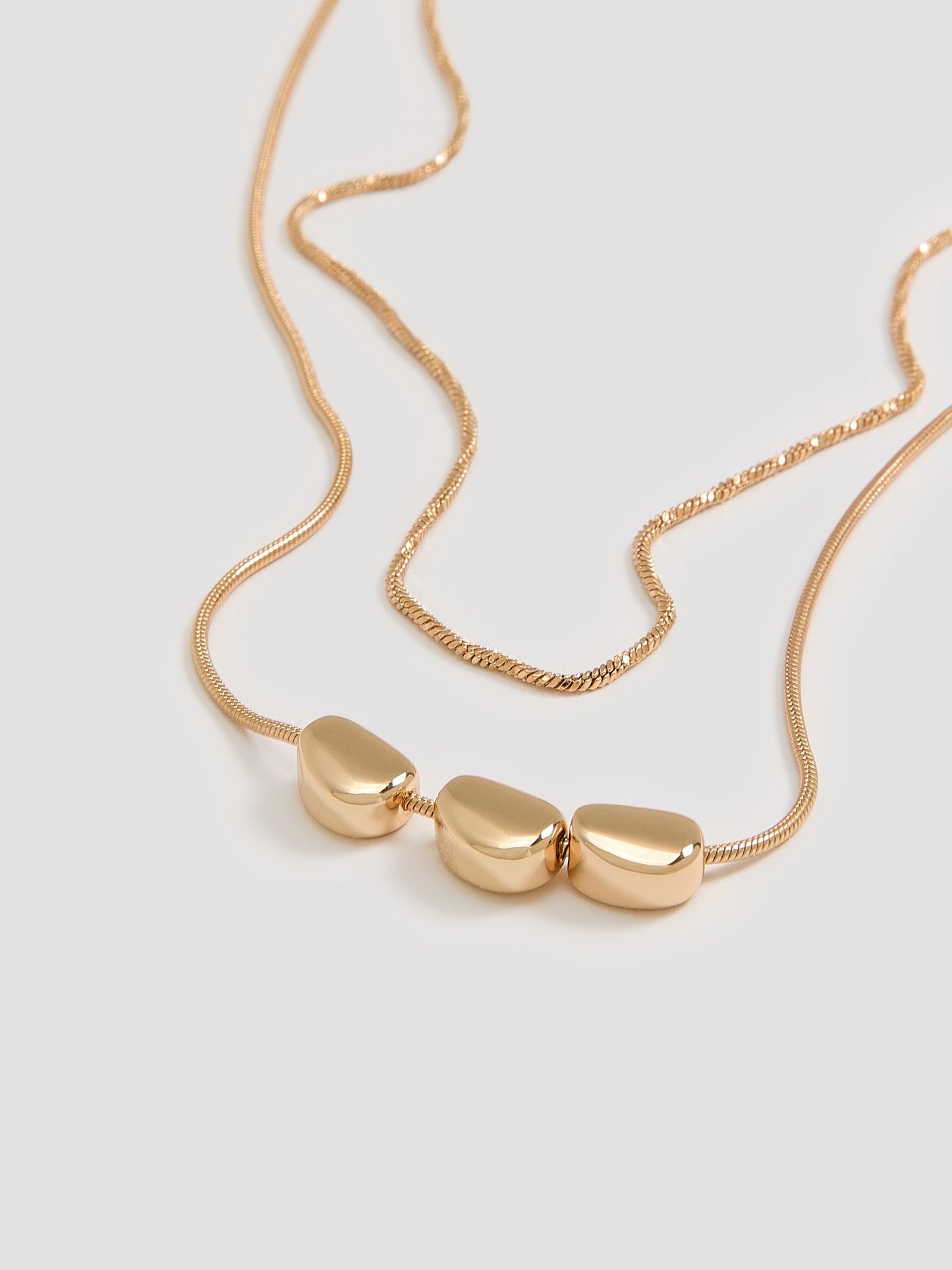 Collier court à deux chaînes avec pendentifs style galet