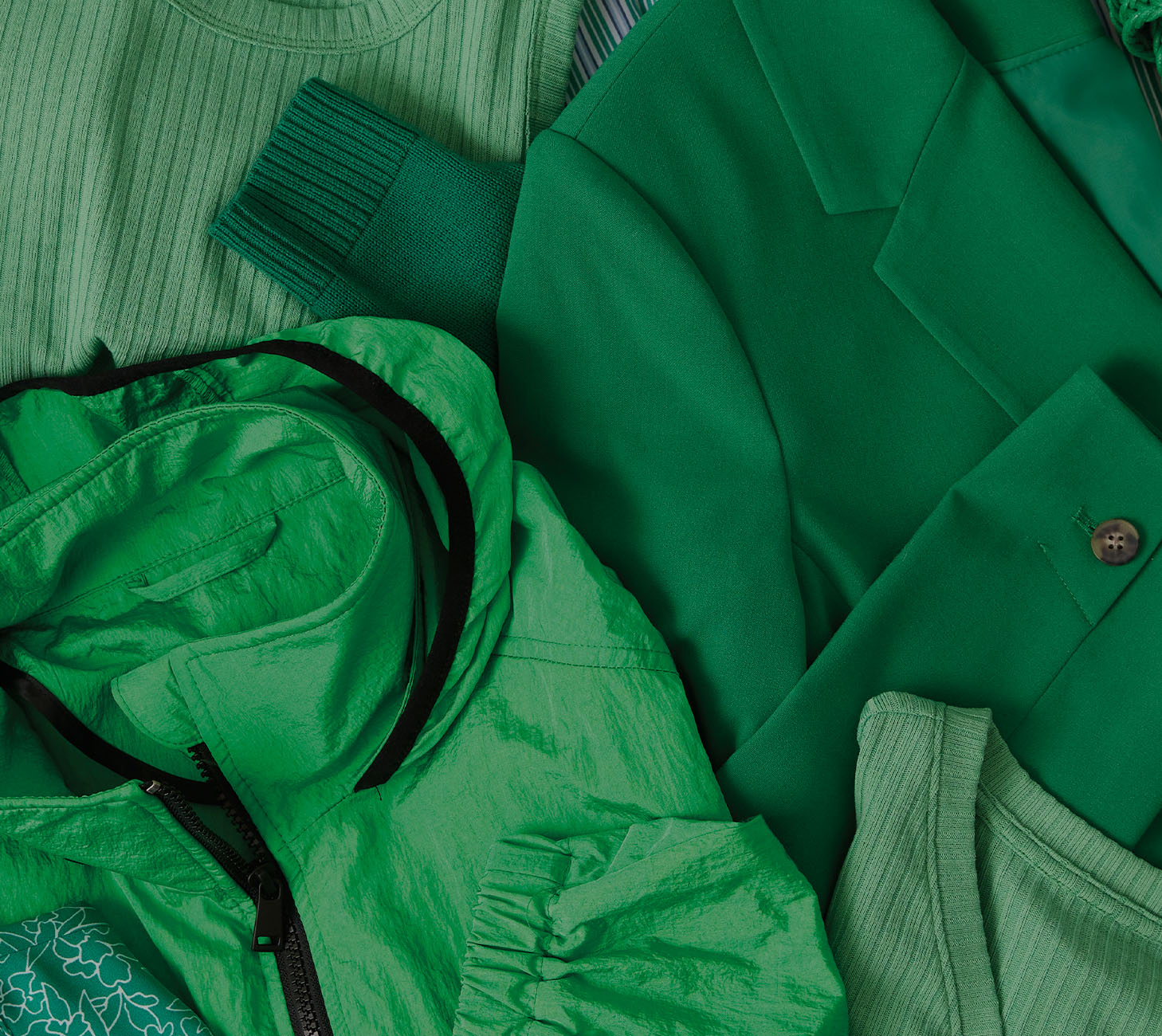 A green jacket, blazer and sweaters all laid out.
