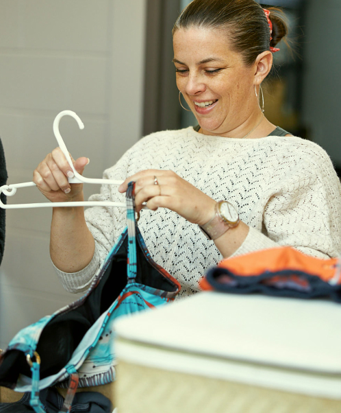A woman sorting donated clothing at a thrift store.