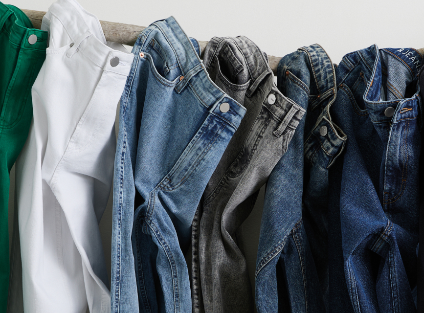 Tissus recyclés REPREVE® utilisés dans les jeans. 5 paires de jeans de différents délavages empilés.